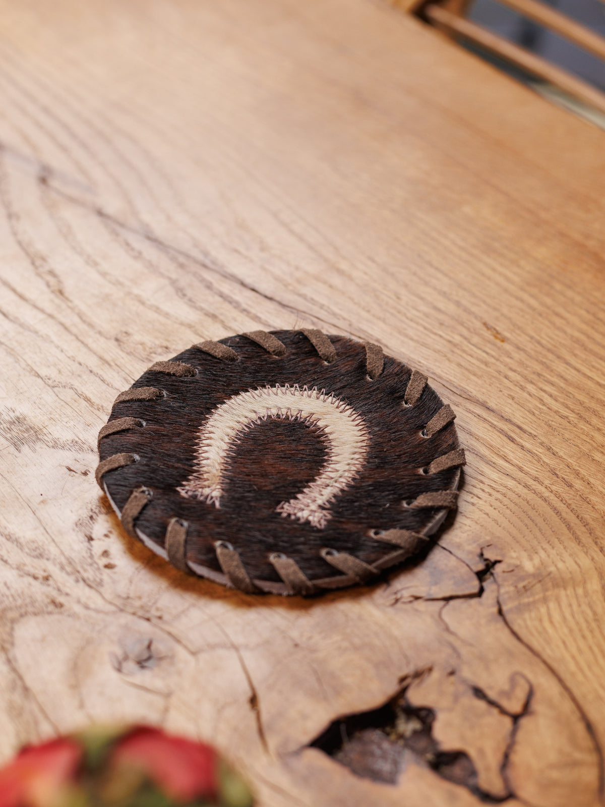 Koeienhuid onderzetter met hoefijzer op een houten tafel, van dichtbij
