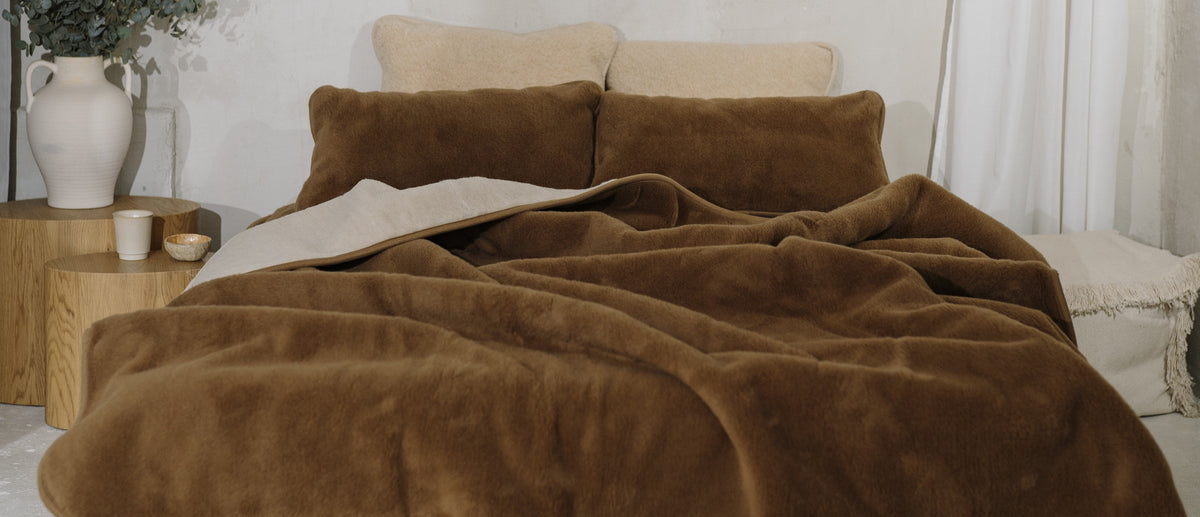 Bruine wollen deken op een bed